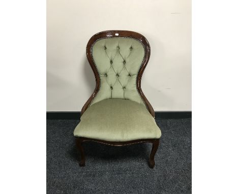 A lady's chair upholstered in green button dralon 