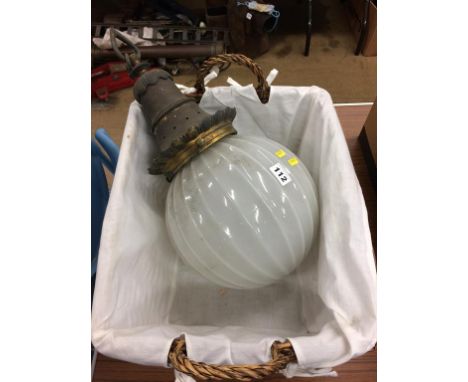 A basket containing a hanging celling light, with opaque globe shade