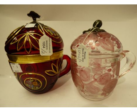 Two 20th Century Bohemian glass cups and covers, one ruby with gilt decoration and cutting, the other with pink floral enamel