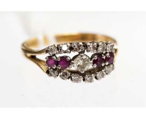 A diamond and ruby ring set central diamond, flanked by two rubies to either side within two rows, each of six brilliant cut 