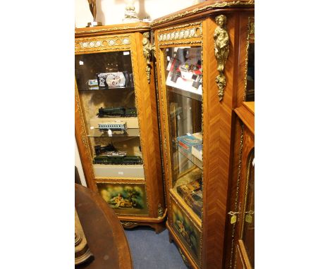 A pair of Louis XV style display cabinets, Kingswood with gilt metal mounts and inset porcelain roundels, the three light gla
