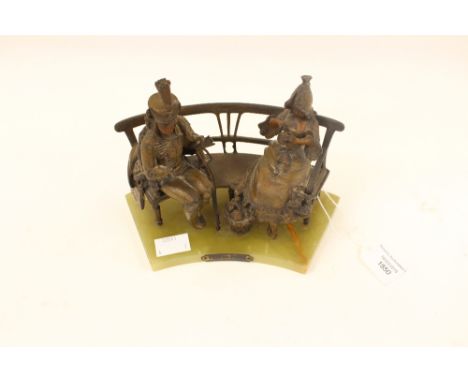 'Pris an Piege Par Maxim' Spelter figure group of a guardsman and lady sitting on a bench, raised on an onyx base 