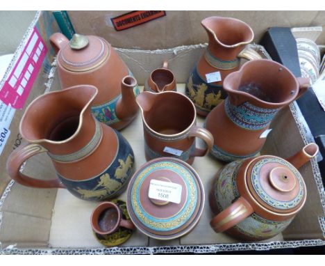 A collection of Prattware terracotta including jugs, teapots and tobacco jar, each with decorated bands, some enamelled polyc