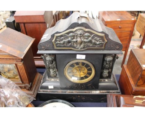 A late Victorian black slate mantel clock of architectural design 