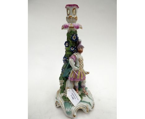 A Derby porcelain figural candlestick, circa 1785, depicting Mars in military costume standing next to a florally encrusted s