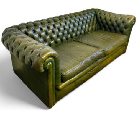 An olive green leather Chesterfield sofa, 65cm x 185cm x 84cm