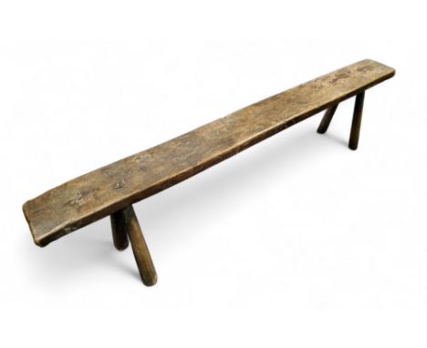 A&nbsp;19th century provincial vernacular elm table-length bench,&nbsp; cylindrical legs, traces of green paint, 44cm high, 1