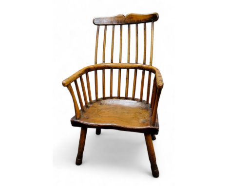 A late 18th century primitive comb-back Windsor chair, of West Country design,&nbsp; shaped cresting rail, dished saddle seat