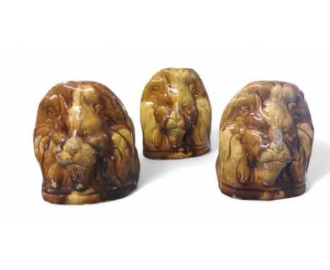 A set of three 19th century Staffordshire treacle glazed sash window stops or furniture rests, each modelled as a lion,14cm h