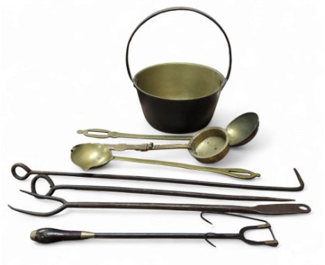 An 18th century iron toasting fork, turned fruitwood handle, 41cm long; a brass ladle, 41cm long; a brass jam pan; etc