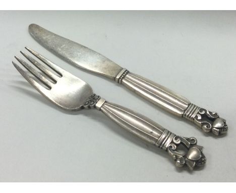 GEORG JENSEN: A silver child's knife and fork of acorn pattern. Approx. 41 grams. Est. £50 - £80.