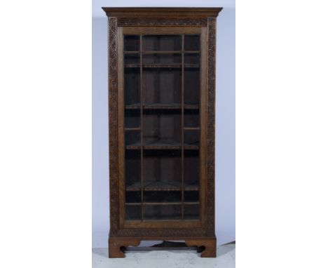 Carved oak bookcase, moulded cornice above glazed panel door, enclosing four fitted shelves, on bracket feet, W84cm x D34cm x