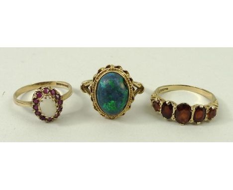 A 9ct gold and garnet five stone ring, size R, 9ct gold and black opal ring, size S, and a 9ct gold and opal ring in a surrou