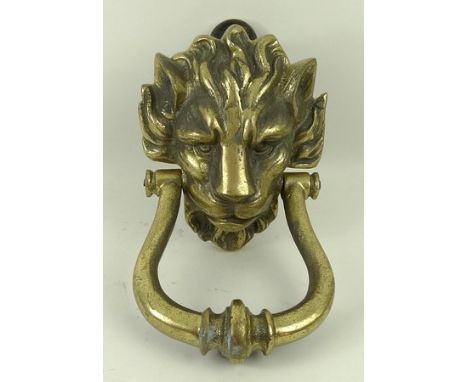 A cast brass door knocker, mid to late 20th century, modelled as a lion's head with a brass ring gripped in it's mouth, 13 by