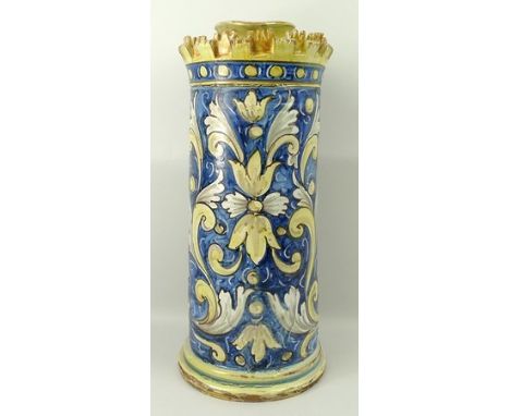 A Spanish maiolica albarello, 19th century, of crenellated cylindrical form, painted with an Oriental mask and scrolling leav