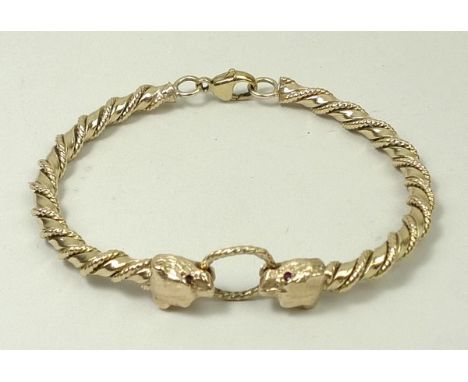 A 9ct gold rope twist bangle with two panthers heads with ruby inset eyes, joined by a twisted ring, stamped RES&S, 31.g. 