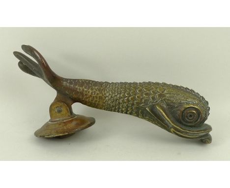 A cast brass door knocker, mid to late 20th century, modelled as a dolphin, 21.5 by 6.5 by 7cm.