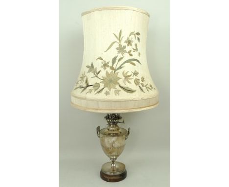 A plated Hinks & Son oil lamp, converted to electricity, of neo-classical twin handled baluster form, raised on a wooden base