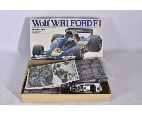 Tamiya Wolf WR1 Ford F1 Kit, a boxed 1:12 scale plastic kit partially constructed, with some packaged components, decals and 