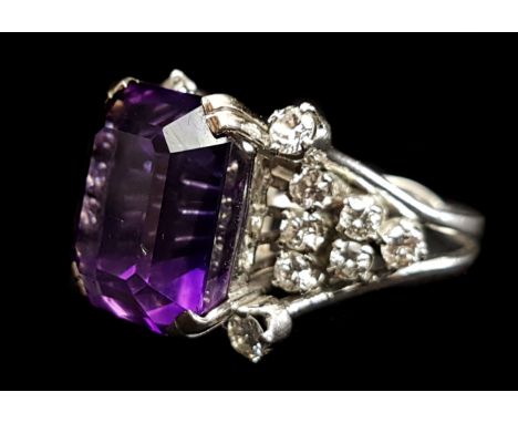 An amethyst and diamond dress ring, the raised central stone set with four brilliant stones to each corner, with five further