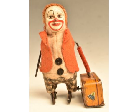 Schuco clockwork tinplate model clown with suitcase with painted facial features and felt clothing, 15cm tall.&nbsp;