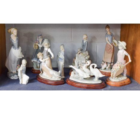 Nine Various Lladro Figures, including boy with a wheelbarrow of flowers etc. (one shelf)