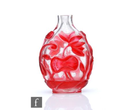 A Chinese red overlay glass snuff bottle, the flattened bottle overlaid in ruby red glass with lotus and foliage, height 6cm.