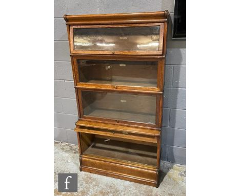 A Globe Wernicke oak four tier modular bookcase with glazed panel doors above a plinth base, height 162cm, width 87cm and dep