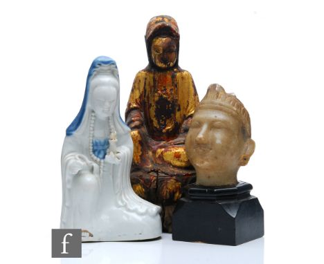 A collection of Asian Buddhistic figures, to include a Chinese glazed figure of Guanyin, height 19.5cm, a gilded wooden figur