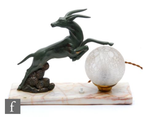 A 20th Century spelter table lamp, decorated with a green painted leaping gazelle, beside a textured frosted glass spherical 