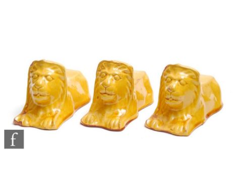 A set of three Georgian style sash rest stops, the yellow ceramic glazed stops in the form of a recumbent lion, height 9cm, l