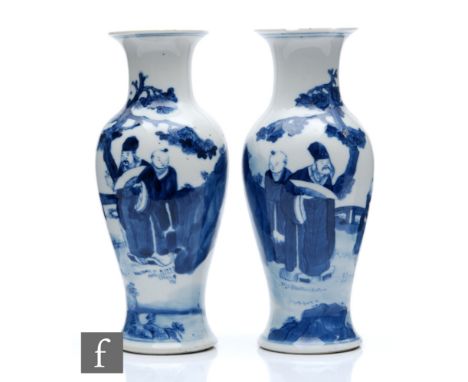 A pair of Chinese 19th Century Kangxi style vases, each of baluster form, rising to a flared rim, decorated in mirror image w