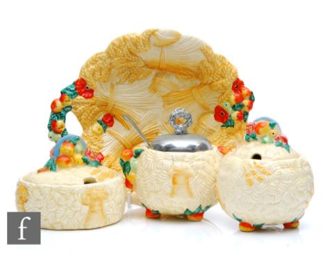 A Clarice Cliff Celtic Harvest shallow circular bowl with integral handle, relief moulded with fruit, foliage and bales of co