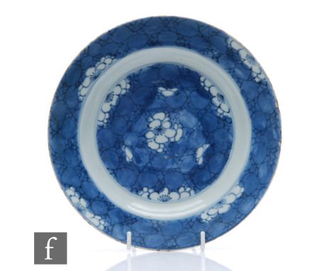 An early 18th Century Chinese blue and white dish of circular form, the cracked ice ground picked out with lotus blooms, Kang