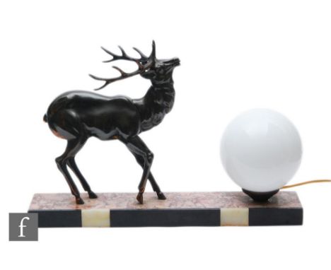 A 20th Century table lamp, decorated with a patinated spelter study of a stylised standing stag, with an opaque white sphere 