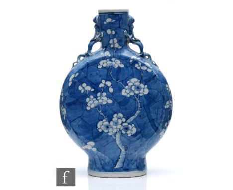 A Chinese 19th Century blue and white 'Prunus' moonflask of rounded form rising from a high footring, the tall neck flanked b