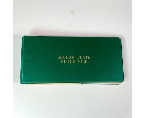 Large assortment of vintage United States postal stamps. Contained within a like-new dark-green vintage Slogan Plate postage 