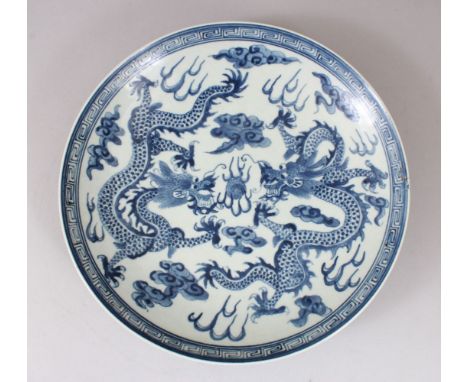 A 19TH / 20TH CENTURY CHINESE BLUE &amp; WHITE MING STYLE PORCELAIN DISH, the interior decorated with scenes of twin dragons 