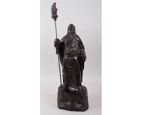 A GOOD 19TH / 20TH CENTURY CHINESE HARDWOOD HARVED FIGURE OF A BEARDED WARRIOR, stood on a tree formed base with foliage hold