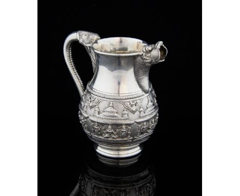 Indian silver jug with embossed figural and temple decoration with scrolling elephant's trunk handle and beast mask spout, by