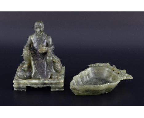 Chinese soapstone carving of a man sitting on a rock and holding a scroll, on shaped integral base, 13cm high, and a dish in 