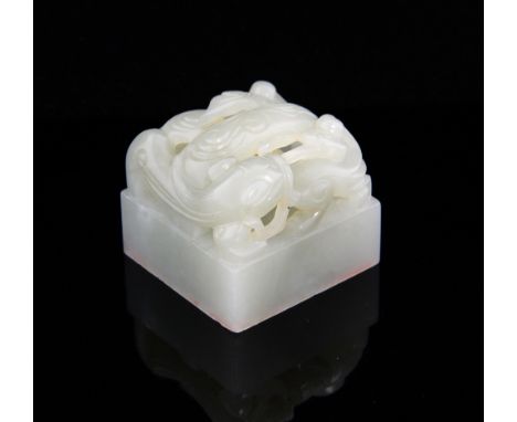 Chinese pale celadon jade seal, of square form carved with four characters and a bifid dragon, 3.8cm high,