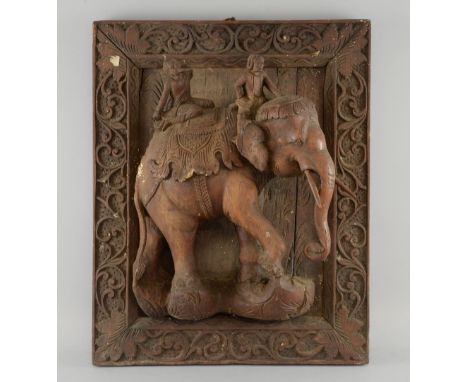 Indian carved hardwood panel with an elephant and riders carved in deep relief framed by scrolling foliage, overall 56cm x 45