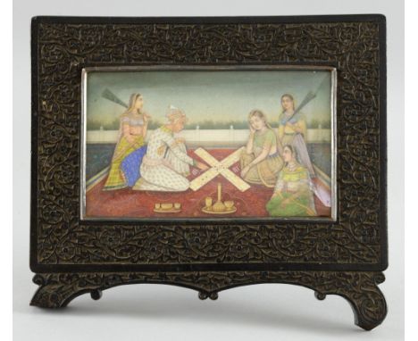 19th century Indian miniature painting on ivory depicting a group of figures, three seated on a carpet playing Pachisi, in an