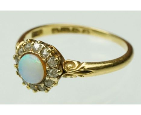 Late 19th century opal and diamond 18ct yellow gold cluster ring, the round cabochon precious white opal displaying violet, g