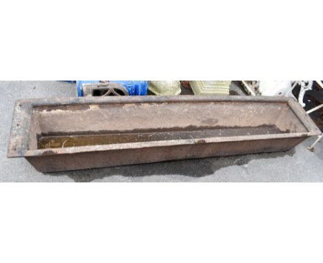 A large cast iron garden trough, length 189cm, width 40cm, height 25cm.