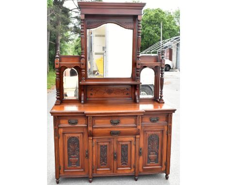 A late Victorian carved walnut mirror back sideboard, the back with three bevelled mirror plates above an arrangement of four