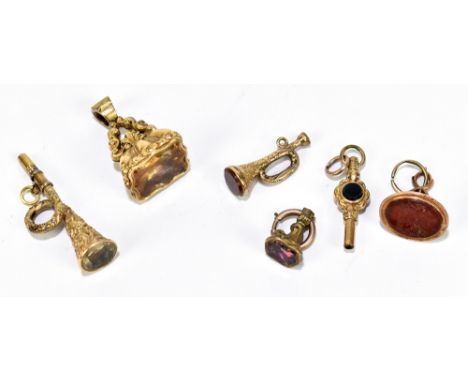 A collection of Victorian yellow metal and gold plated fobs and seals including an example in the form of a trumpet, a clock 