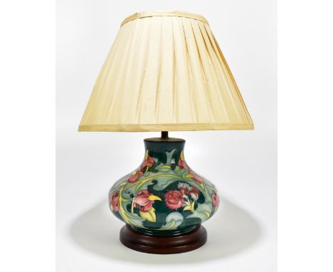 MOORCROFT; a modern baluster form table lamp with floral decoration on a green ground, on wooden plinth base, height 18cm.Add