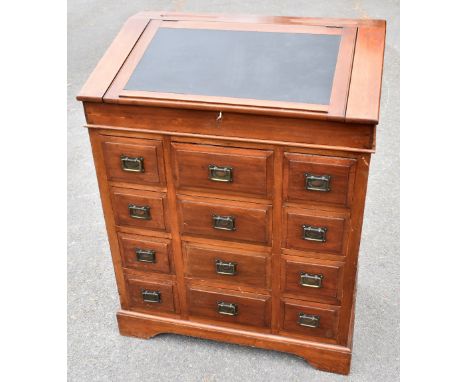 A late 19th/early 20th century walnut lectern type desk, the fall front enclosing fixed shelf above twelve drawers, on shaped